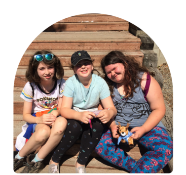 A group of three campers pose for the camera at Camp Robbinswold, an LGBTQ+ youth camp hosted by Girl Scouts of Western Washington. It