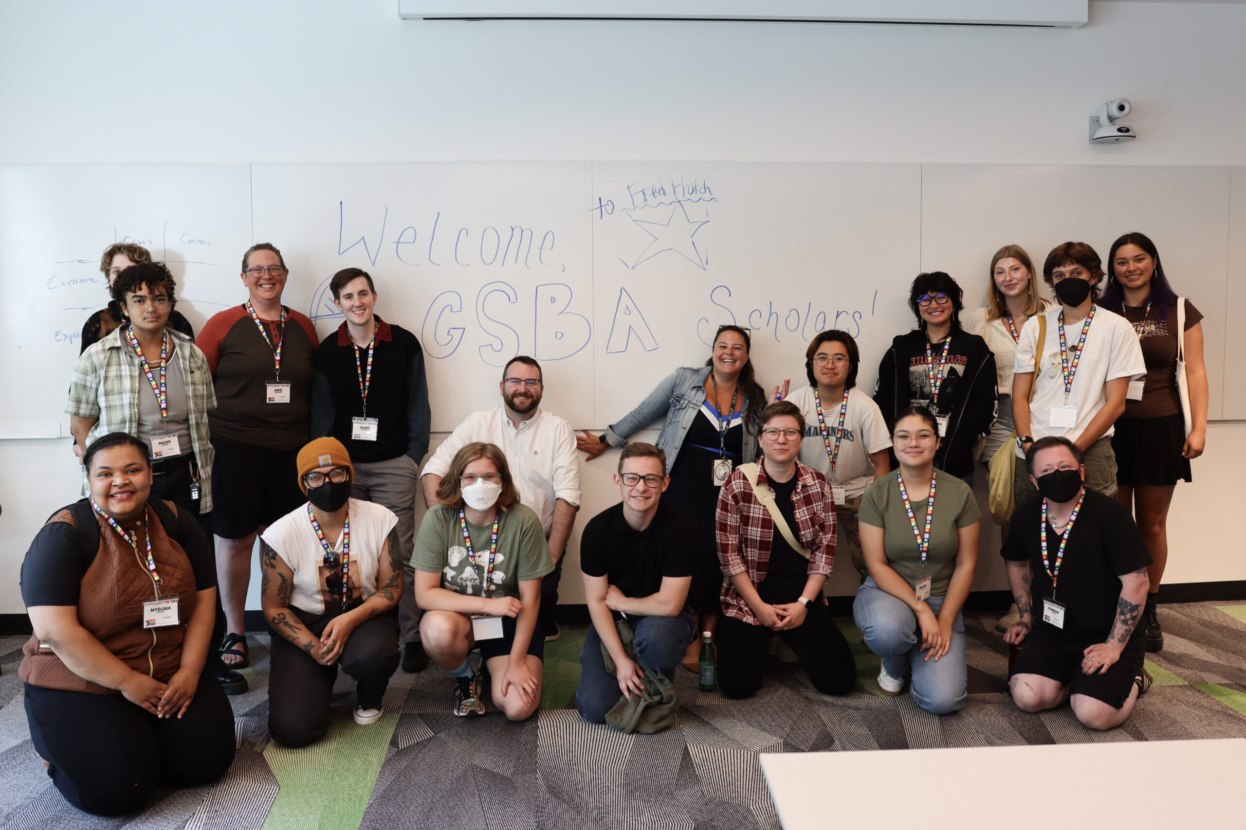 2025's new scholars pose in front of a welcome sign at Fred Hutchinson Cancer Center